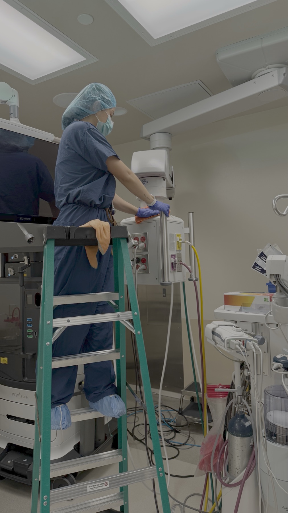 Technician on a ladder above OR equipment